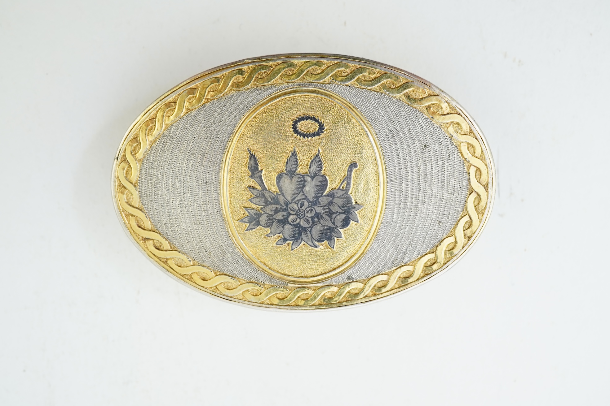 A 19th century Swiss? parcel gilt white metal oval snuff box with hinged cover